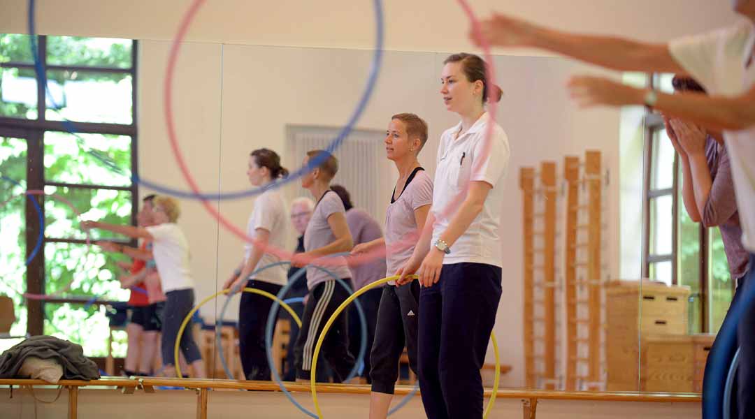 Gruppentraining mit bunten Reifen in der Sporthalle