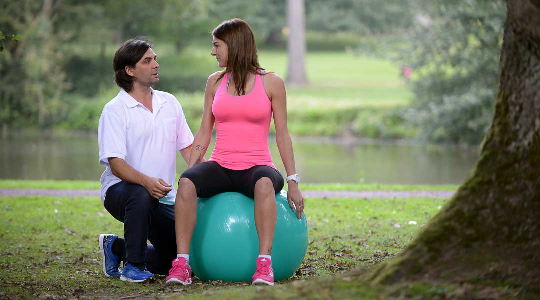 Physiotherapie Übung mit dem Gymnastikball im Park